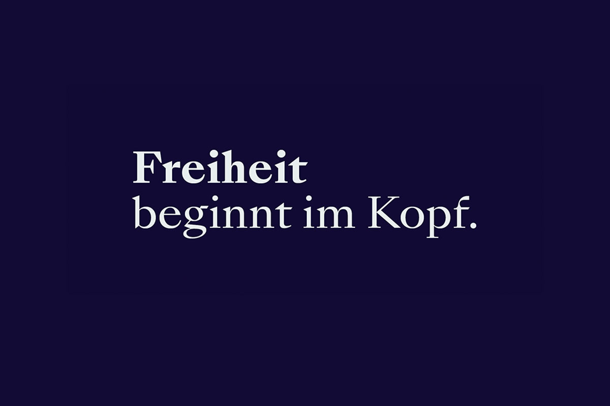 Schrift Freiheit beginnt im Kopf auf dunkelblauem Hintergrund